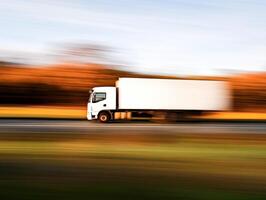 Truck driving fast along a highway in autumn scenery photo
