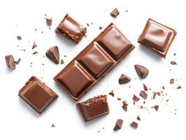Chocolate bar with broken pieces and chocolate chips scattered around photo