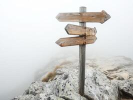 Wooden directional signpost in foggy mountain landscape photo