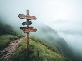Foggy mountain trail with directional signs guiding hikers photo