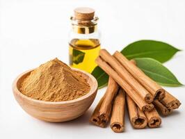Cinnamon powder and sticks with essential oil on a white background photo