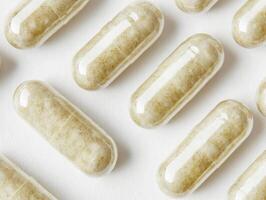 Natural herbal capsules on a white surface for health improvement photo