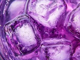 Bright purple beverage with ice cubes in a glass filled with fizz photo