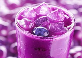 Refreshing purple beverage served in a glass with ice cubes photo