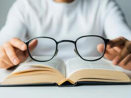 Reading with glasses enhances focus on open book's text photo