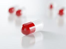 Red and white capsule lying on a clean surface with others nearby photo