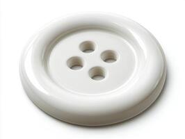 White button with four holes resting on a clean surface photo