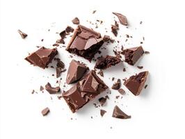 Delicious dark chocolate pieces scattered on white background photo