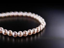 Elegant pearl necklace displayed on sleek black surface photo