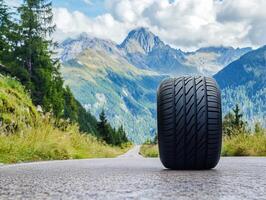Mountains surround a lonely tire on a winding road photo
