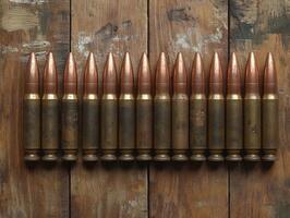 Collection of military bullets displayed on wooden surface photo