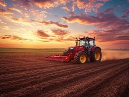 Tractor plowing field at sunset with colorful skies photo