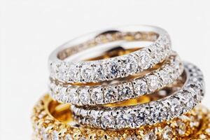 Elegant diamond rings stacked together on light background photo