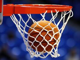 Basketball entering hoop during a competitive game at a gymnasium photo