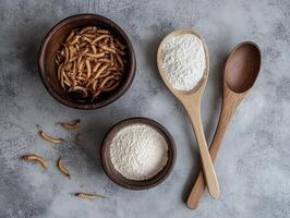 Edible insects and flour displayed on a textured surface photo