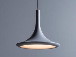 Sleek modern pendant light hanging against a gray background photo