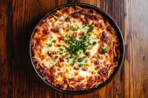 Delicious baked pasta with cheese and herbs served warm photo