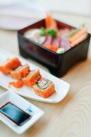 Fresh sushi rolls and sashimi served with soy sauce photo