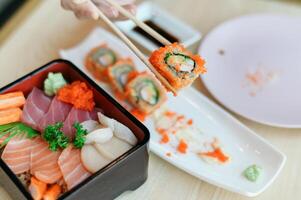 Sushi platter with sashimi and rolls on wooden table photo