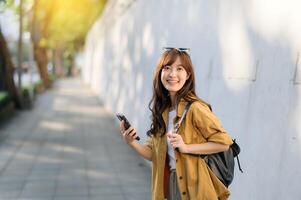 Traveler young asian woman in her 30s explores Bangkok's vibrant scene with her phone. Discover the excitement and freedom of solo adventures. photo