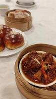 Two plates of food on a table with a bowl of sauce video