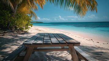 Wooden picnic table under palm trees on tropical beach photo