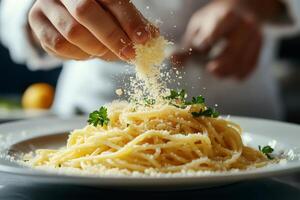 Chef sprinkling grated cheese over spaghetti with parsley garnish photo