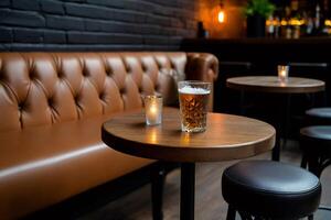 Glass of cold beer and candle resting on table in cozy pub photo
