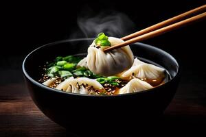 Steaming hot dumplings being lifted from broth with chopsticks photo