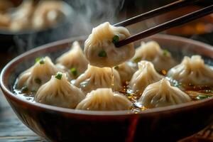 Chopsticks lifting steaming hot soup dumpling from bowl photo