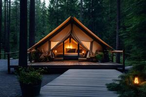 Glamping tent illuminated at dusk in a coniferous forest photo