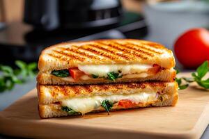 Delicious grilled cheese sandwich with tomato and spinach on wooden cutting board photo