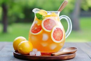 Refreshing citrus lemonade with grapefruit and lemon slices in glass pitcher photo