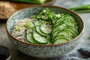 Soba noodles with sliced cucumbers and sesame seeds in rustic bowl photo