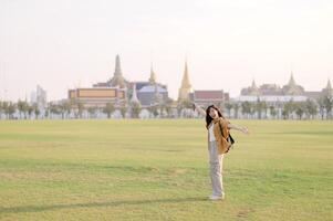 A woman standing in the middle of a field with a building in the background photo