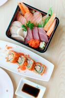Fresh sashimi and sushi rolls served with soy sauce photo