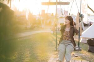 A woman sitting on a swing in the grass photo