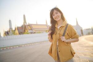 Asian woman in yellow jacket standing in front of a building photo