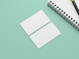 A top view of two clean business cards, with a spiral notepad and a black pen on a white background. photo