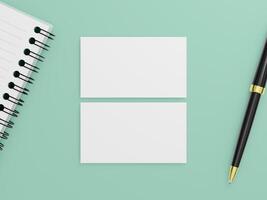 A top view of two blank business cards on a flat background with a spiral notebook and a black pen. photo