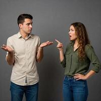 A man and woman are pointing at each other photo