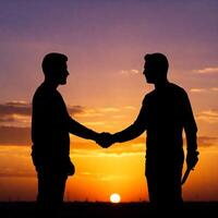 Two men shaking hands at sunset photo
