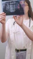 Dentist compares X-ray images to assess treatment progress and identify potential issues. video