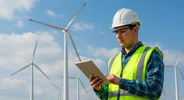 A man in a hard hat and vest holding a tablet computer photo
