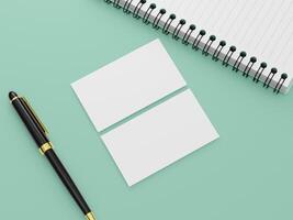 A business card mockup with two blank cards on a flat background, with a pen and a notebook. photo