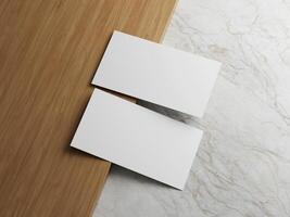 Two white business cards placed on a wooden surface with a marble background, offering a sleek and professional layout. photo