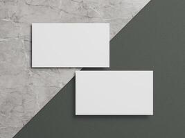 Stylish business card mockup with two white cards resting on a marble and dark green textured background. photo