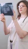 The dentist analyzes an X-ray image to identify inflammatory processes in the jaw and teeth. video