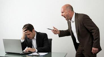 Two men in suits are arguing over a laptop photo