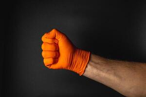 Orange gloved fist symbolizes strength and determination photo